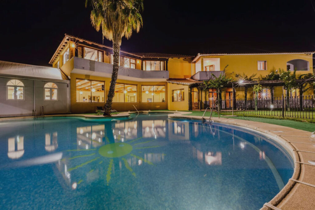 Foto Complejo Oro Verde de noche con luces encendidas y la piscina de fondo